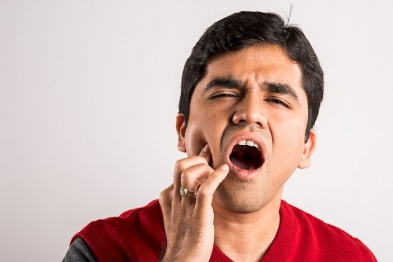 Young man suffers from tooth ache, indian man and tooth ache, as